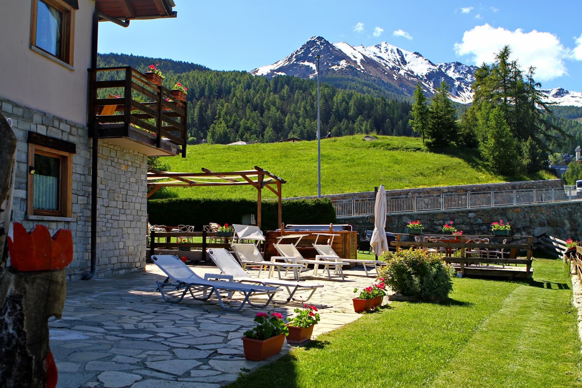 Lato chalet con lettini e montagna